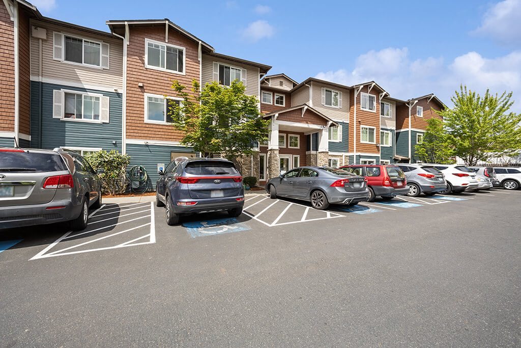 Exterior of apartments and parking area at Ballinger Court Senior Apartments in Edmonds WA